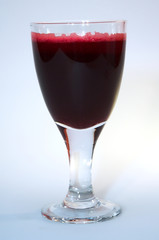 Red drink in wine glass on white background