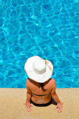 Fototapeta na wymiar Young woman relaxing by the pool