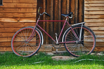 Fototapeta na wymiar Vintage red bicycle near a wooden house