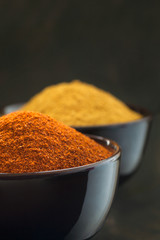 Chilli and curry powder in black bowls