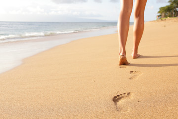 Fototapeta na wymiar Beach travel - woman walking on sand beach closeup