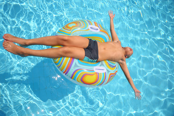 Man sunbathes lying on an inflatable toy with eyes closed