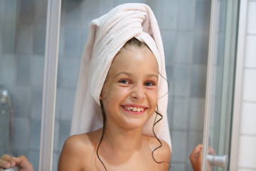 A smiling girl with towel on his head out of shower