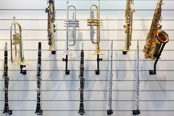 The wind instruments hanging on wall in the shop.