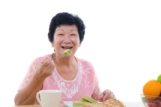 chinese senior female eating with isolated white background