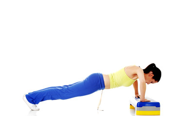 Fitness girl is working out with stepper.