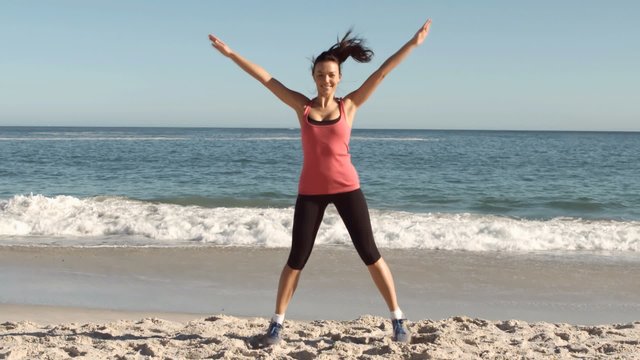 Happy attractive woman working out on the beach