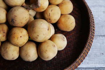 Longkong,  Wollongong  in threshing basket on wooden table