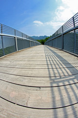 long bridge with a wooden walkway and handrail made of galvanize