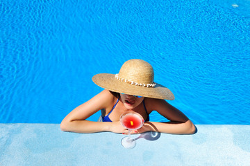 Woman at poolside with cosmopolitan cocktail