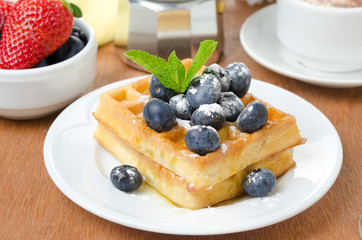 Belgian waffles with blueberries, coffee and fresh fruit
