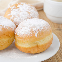 three donuts sprinkled with powdered sugar