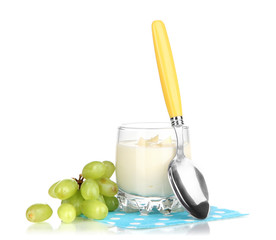 Delicious yogurt in glass with grapes isolated on white