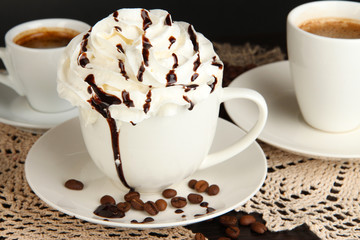 Cup of whipped cream coffee on wooden table close up