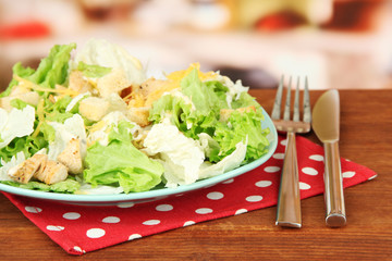 Caesar salad on blue plate, on bright background
