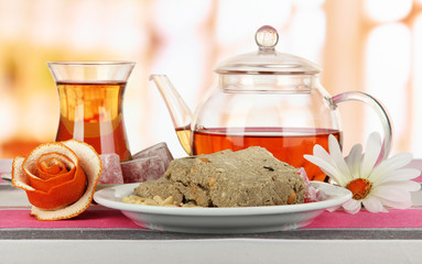 Tasty halva with tea on table in room