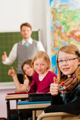 Fototapeta premium Education - Teacher with pupil in school teaching