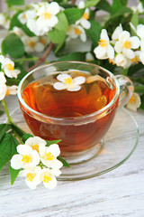 Cup of tea with jasmine, on wooden table, close-up