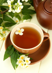 Cup of tea with jasmine, on wooden table, close-up