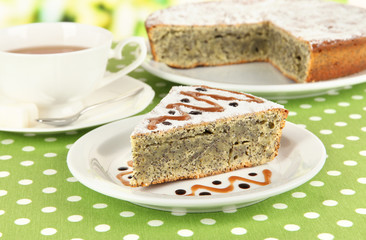 Delicious poppy seed cake with cup of tea on table close-up