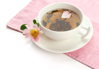 Cup of herbal tea with hip rose flowers, isolated on white