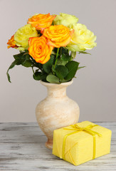 Beautiful bouquet of roses in vase with gift