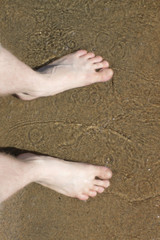 feet on the sandy beach
