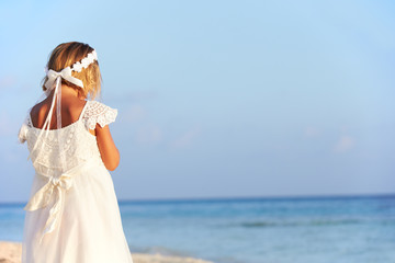 Fototapeta na wymiar Bridesmaid Standing On Beach At Wedding Ceremony