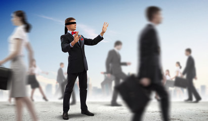 Businessman in blindfold among group of people