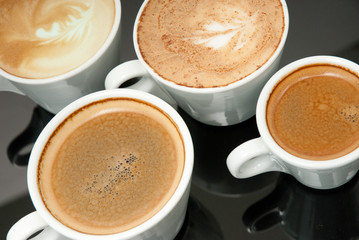 four white coffe cups on the black background