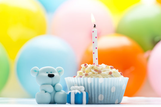 Birthday cupcake with candle and sugar teddy