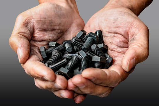 Workers hands with a few black bolts