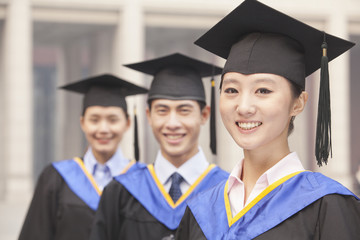 Three University Graduates Smiling in a Row