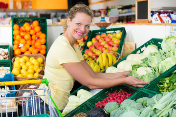 frau im supermarkt an der gemüsetheke