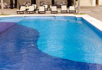 Empty chaise lounges near  pool