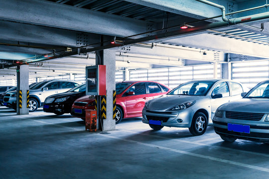 Parking garage, interior with a few parked cars.