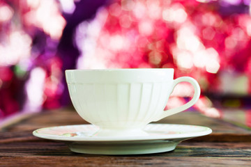 A cup of Capuchino coffee in a white cup on wooden background