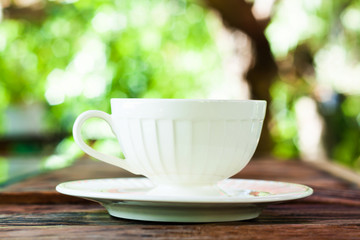 A cup of Capuchino coffee in a white cup on wooden background