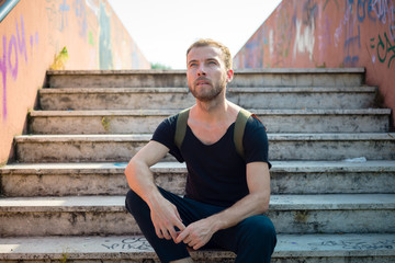 hipster modern stylish blonde man sitting in stairs