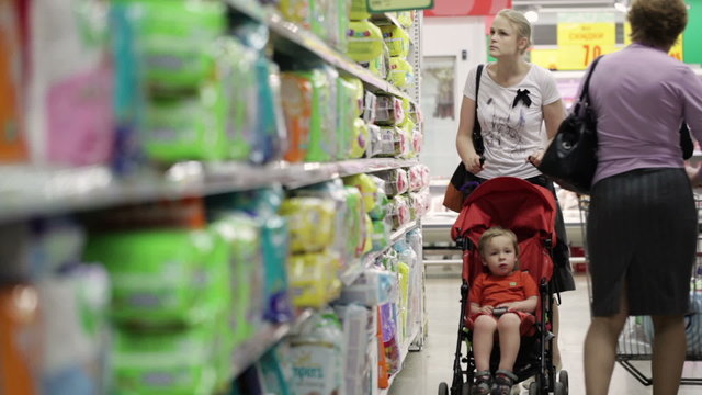 Mother with her boy in baby carriage in the supermarket