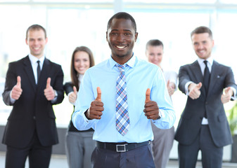 Successful young business people showing thumbs up sign