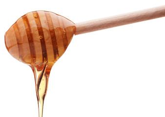 Honey dripping from a wooden honey dipper isolated on white back