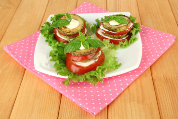 Tasty roasted marrow and tomato slices with salad leaves,