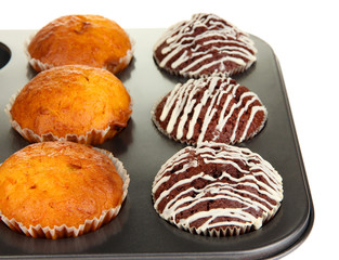 Tasty muffin cakes in baking tray close up