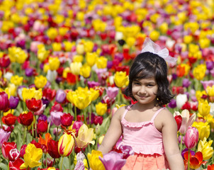 Obraz na płótnie Canvas A cute girl in a tulip field