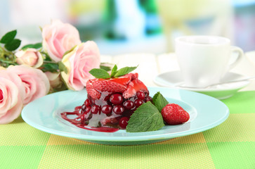 Tasty jelly dessert with fresh berries, on bright background
