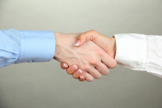 Business handshake on gray background
