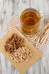 Beer in glass crunches, and nuts on napkin on wooden table