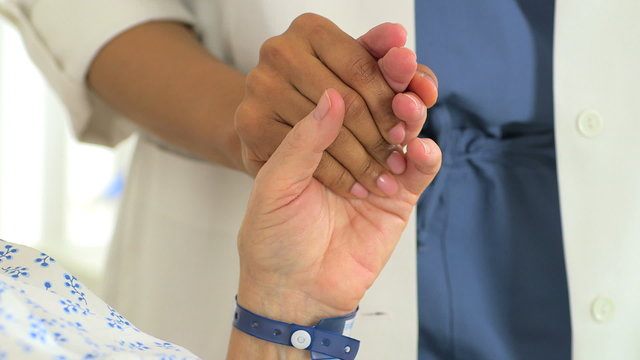 Close-up of Female African doctor holding her Caucasian patient'