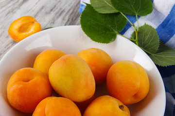 Apricots on board for cutting on napkin on wooden table